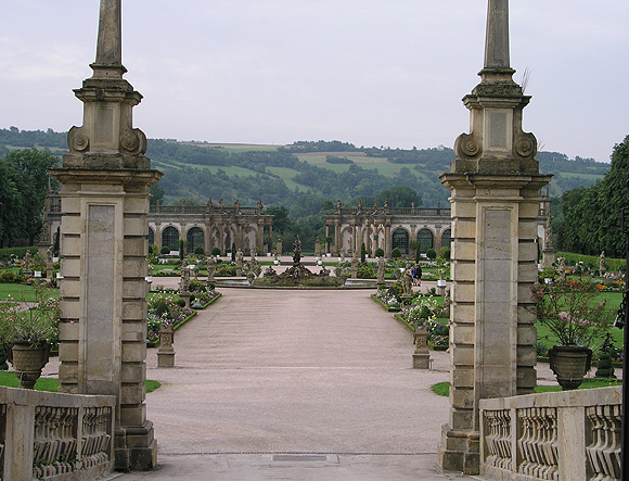 Brücke über den Schlossgraben als Zugang zum Gartenparterre, von Obelisken flankiert. In der Mitte der Herkulesbrunnen, im HIntrergrund die Orangerien