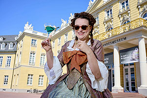 Dame im barocken Kostüm vor dem Museum. 