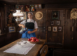 Frau in der Tracht Kinzigtäler Bäurinnen schenkt Apfelmost ein