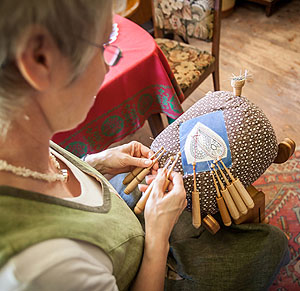 Eine Spitzenklöpplerein führt ihr traditionelles Handwerk vor und lädt zumMitklöppeln ein. Foto: Vogtsbauernhof